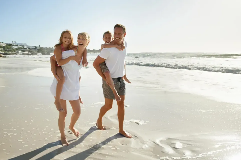Couple walking on the beach with their two kids on vacation in Deltona, Florida